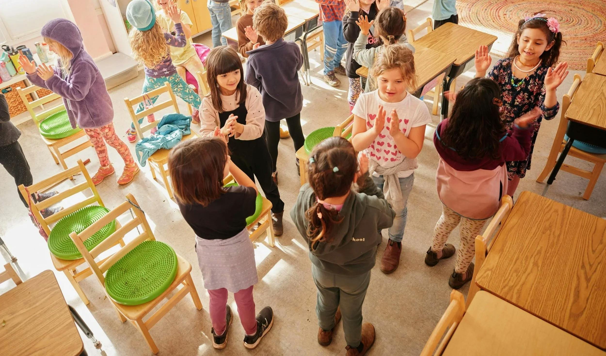 Children clapping their hands in a classroom