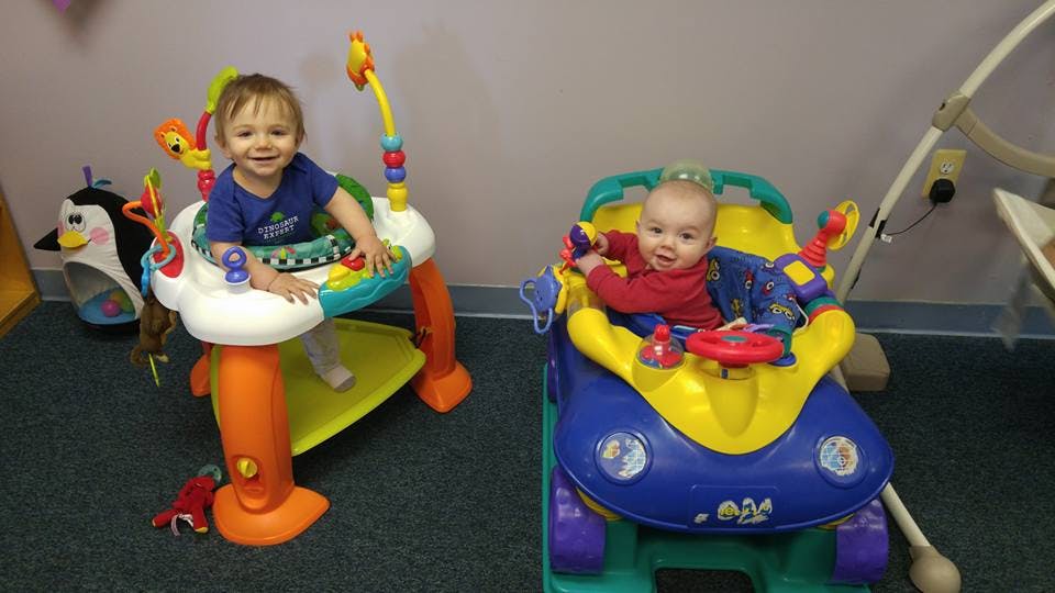 Two children in baby activity centers