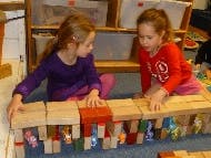 Two children playing with wooden blocks