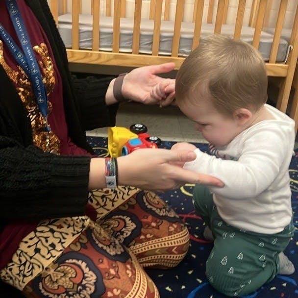 Adult and child playing patty-cake