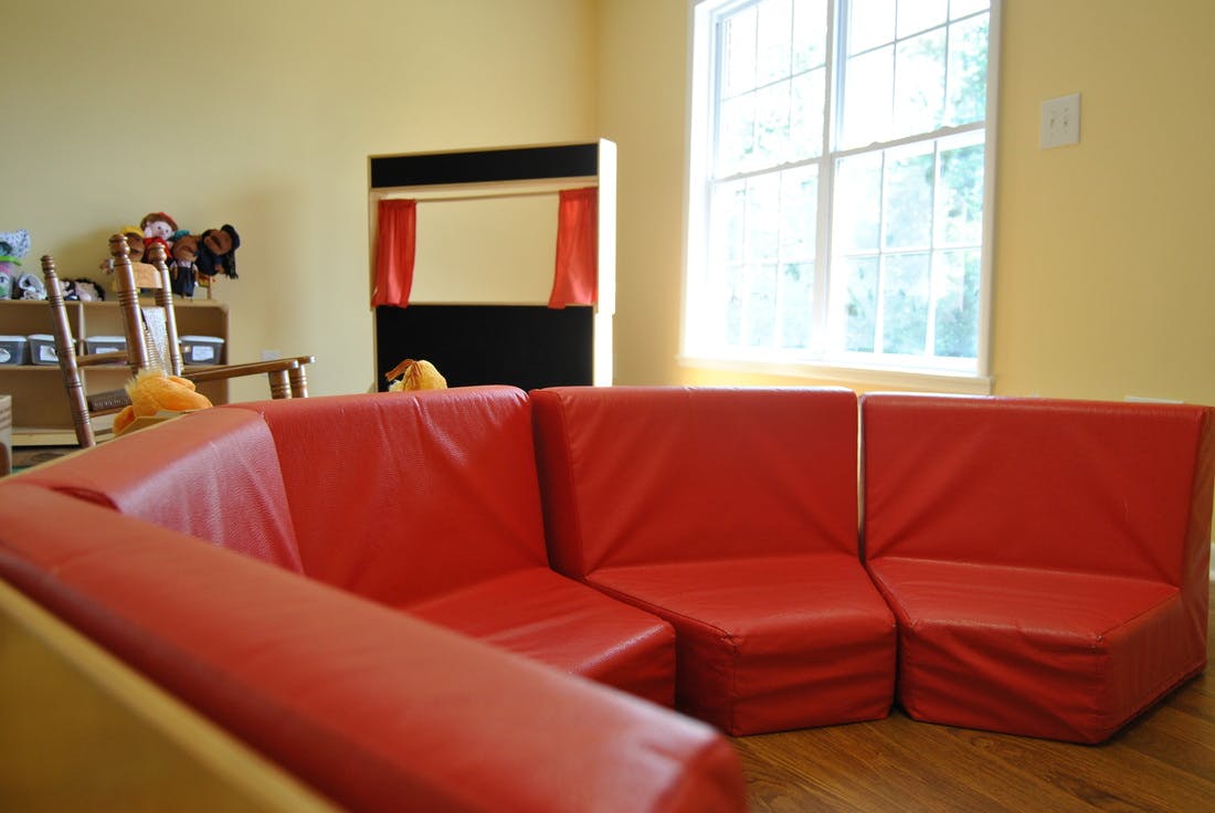 Red modular seating in a classroom with a puppet stage