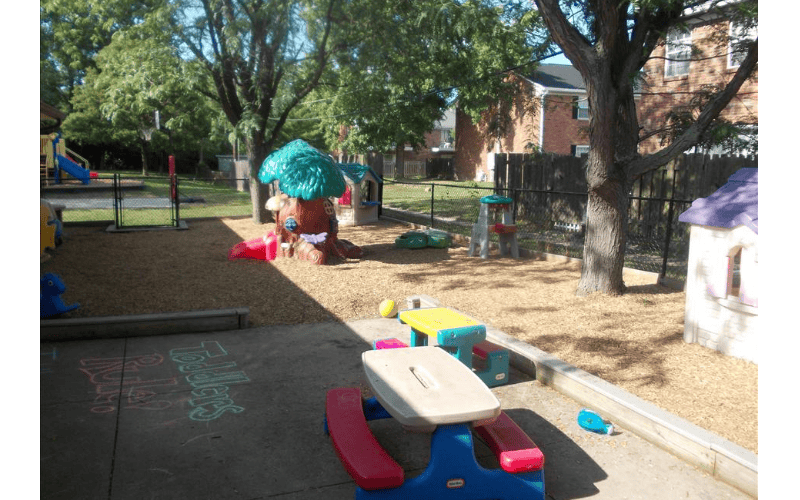 Outdoor children's play area with playground equipment and a picnic table
