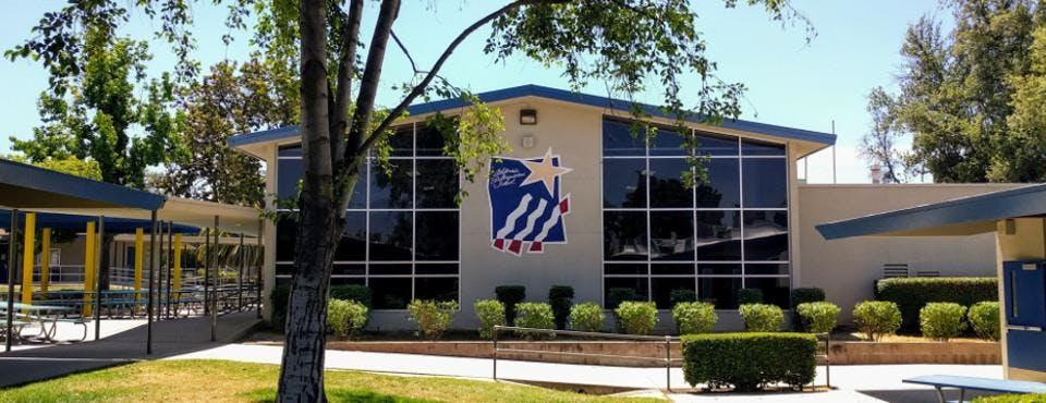 Building with large windows and a blue and white emblem on the facade