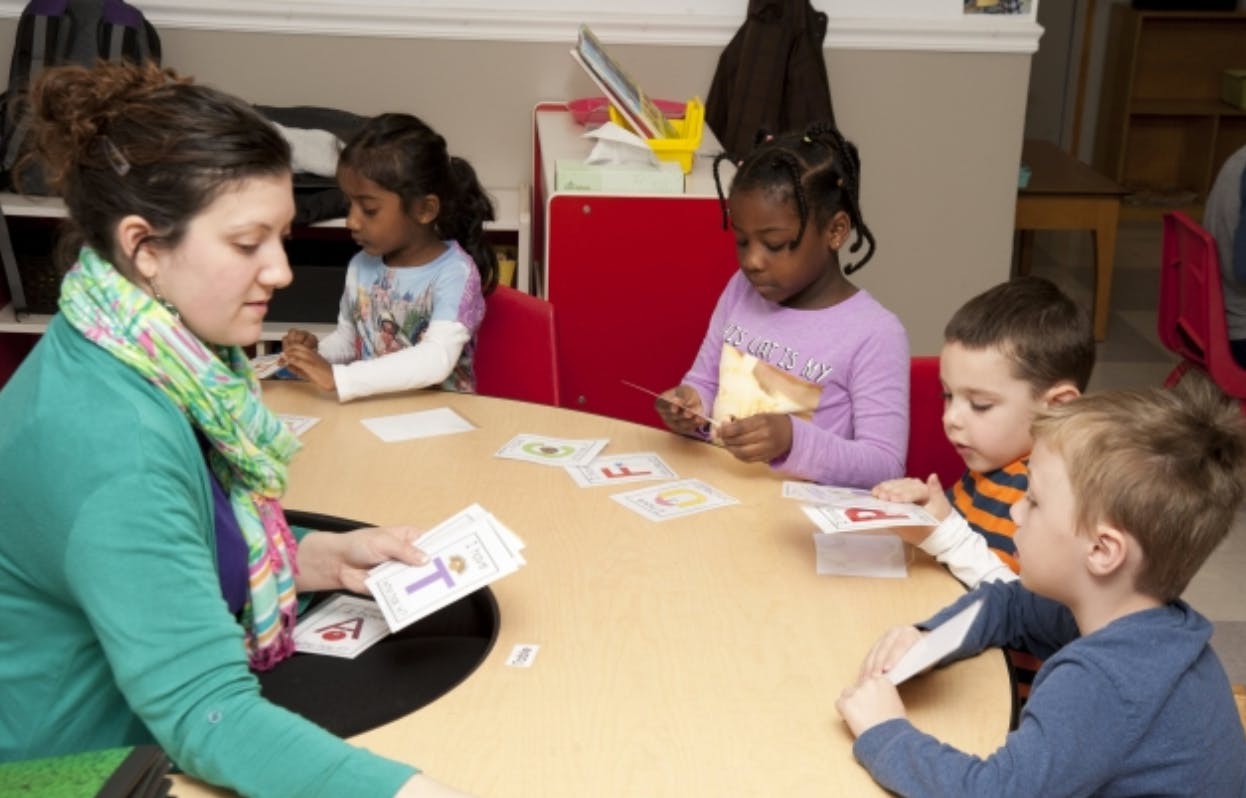 Adult and children at a table with cards