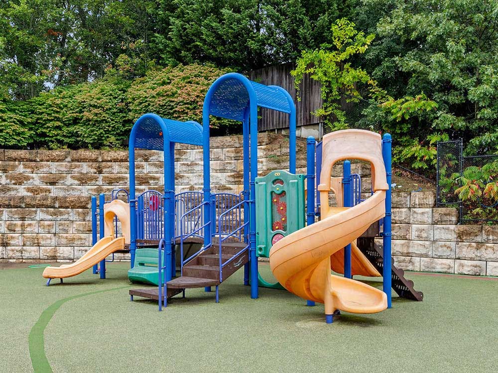 Empty outdoor playground with slides and climbing structures