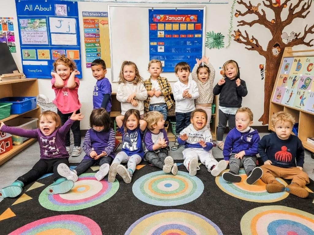 Group of children playing and smiling in a classroom