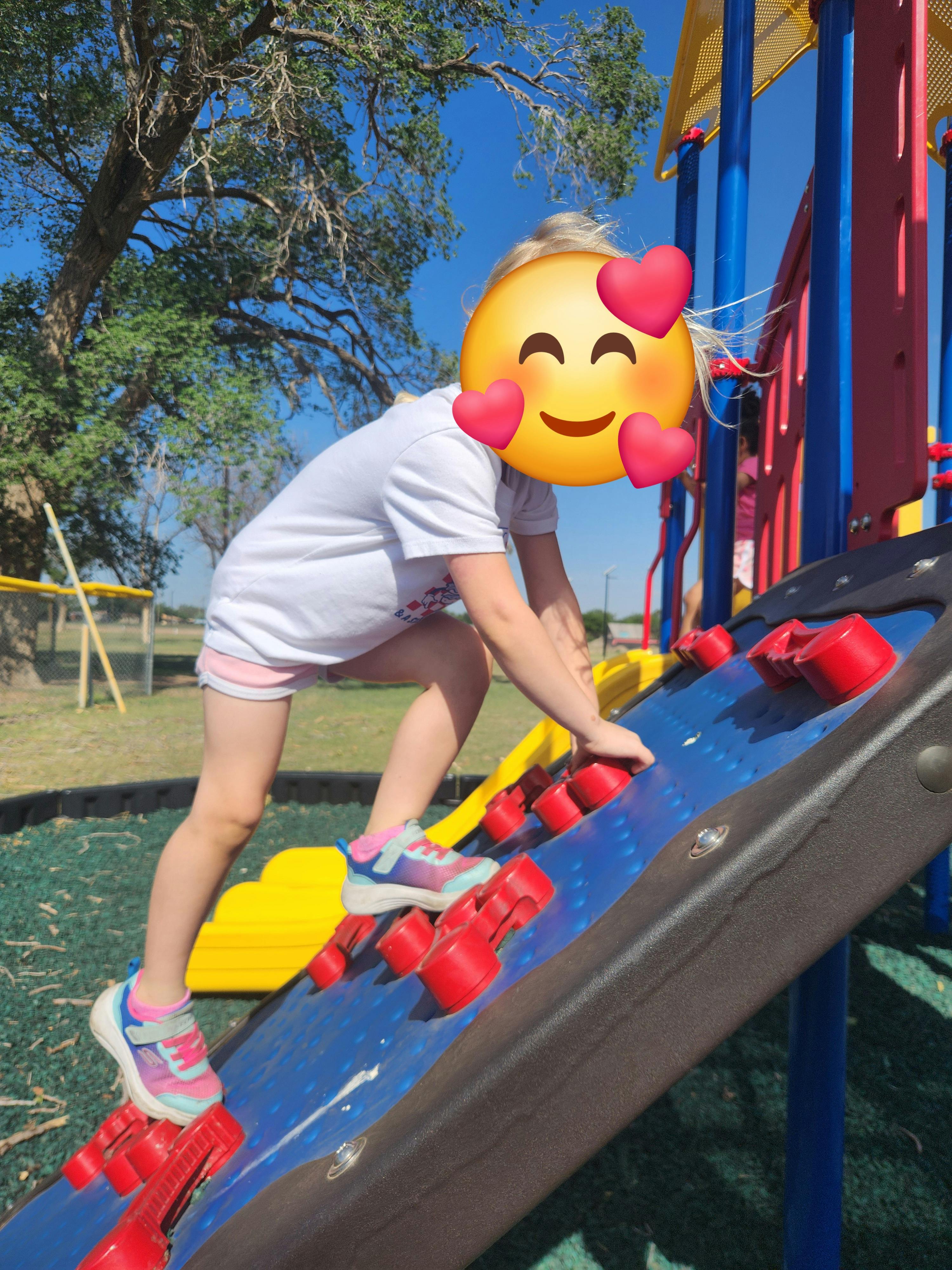 Child climbing a playground wall