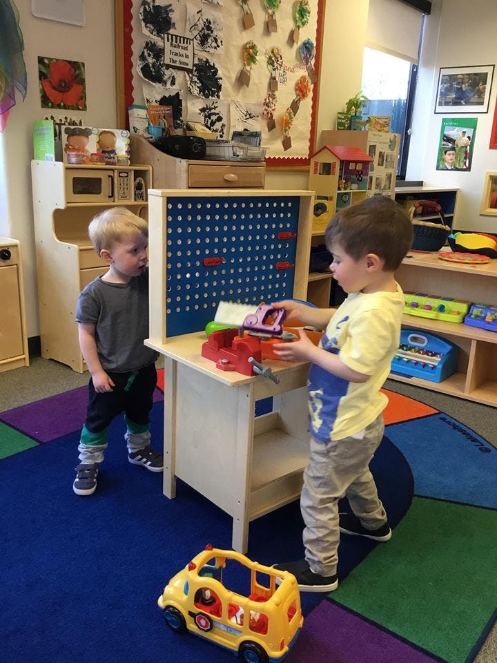 Two children playing with toys in a classroom