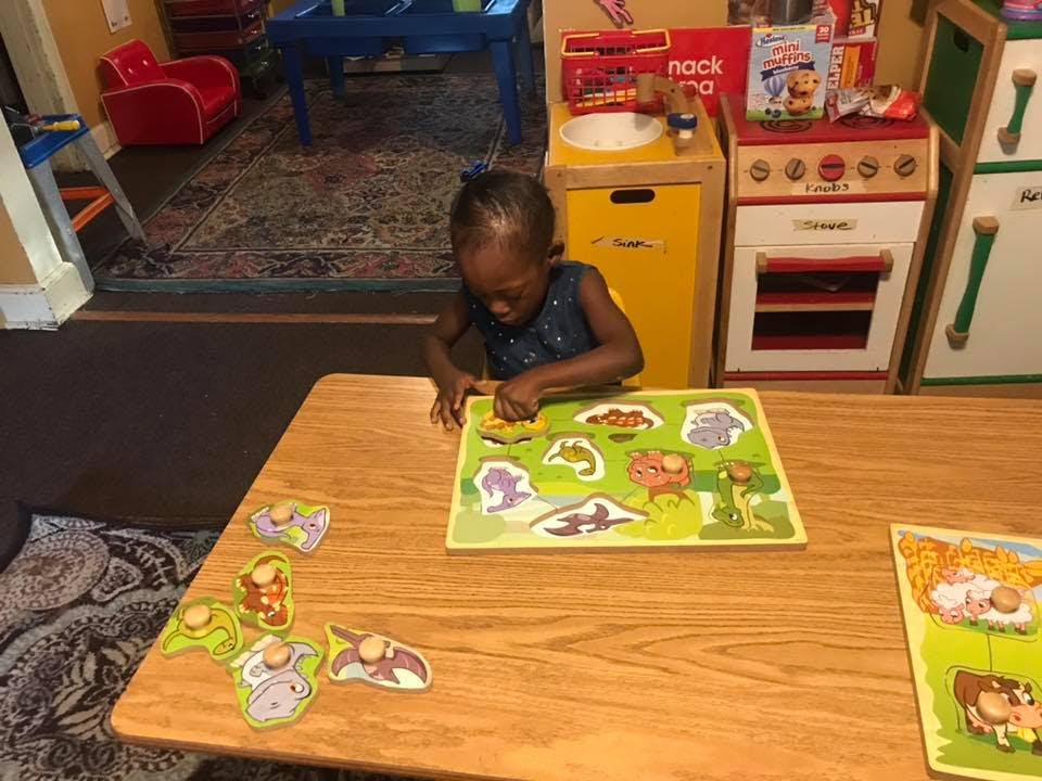 Child playing with a puzzle at a table