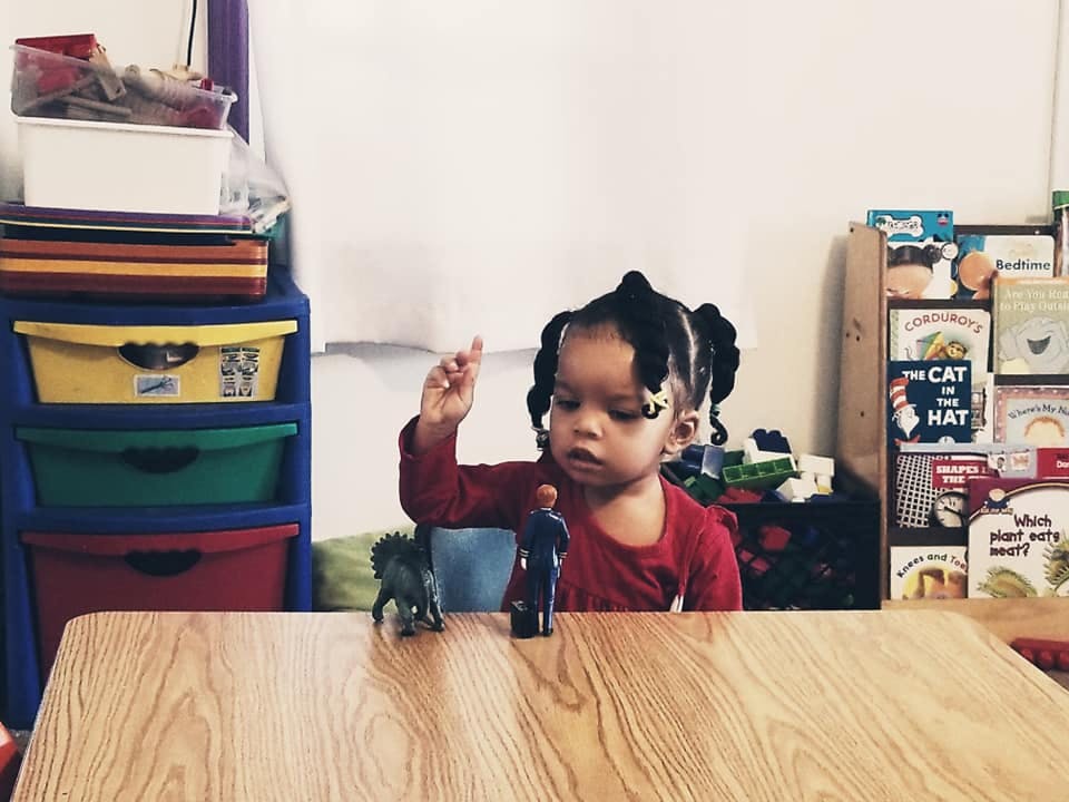 Child sitting at a table with toys