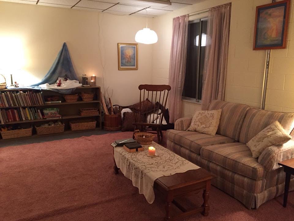 Living room with a sofa, coffee table, bookshelf, and rocking chair