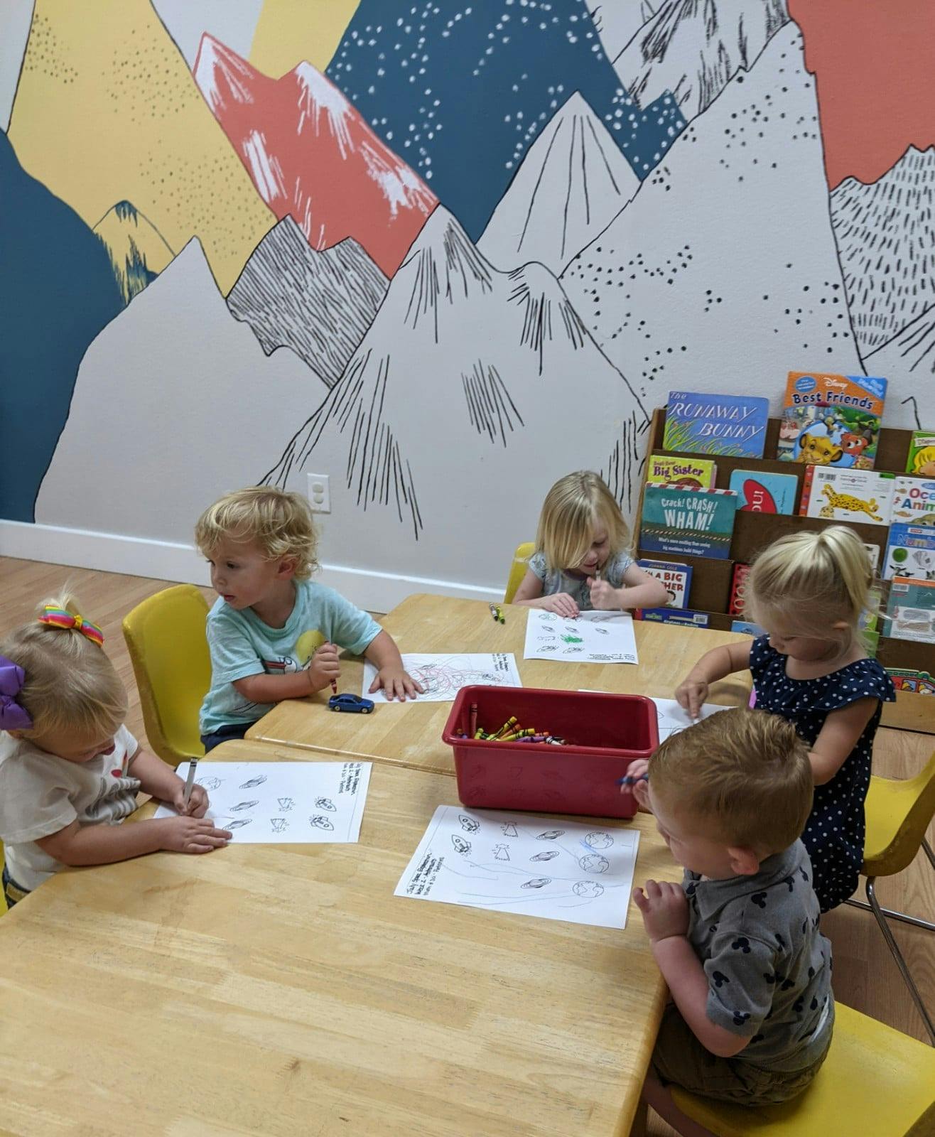 Children sitting at tables and drawing