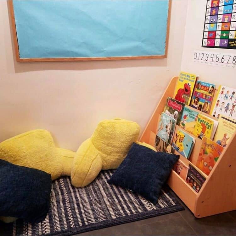 Reading nook with a book display, pillows, and a rug
