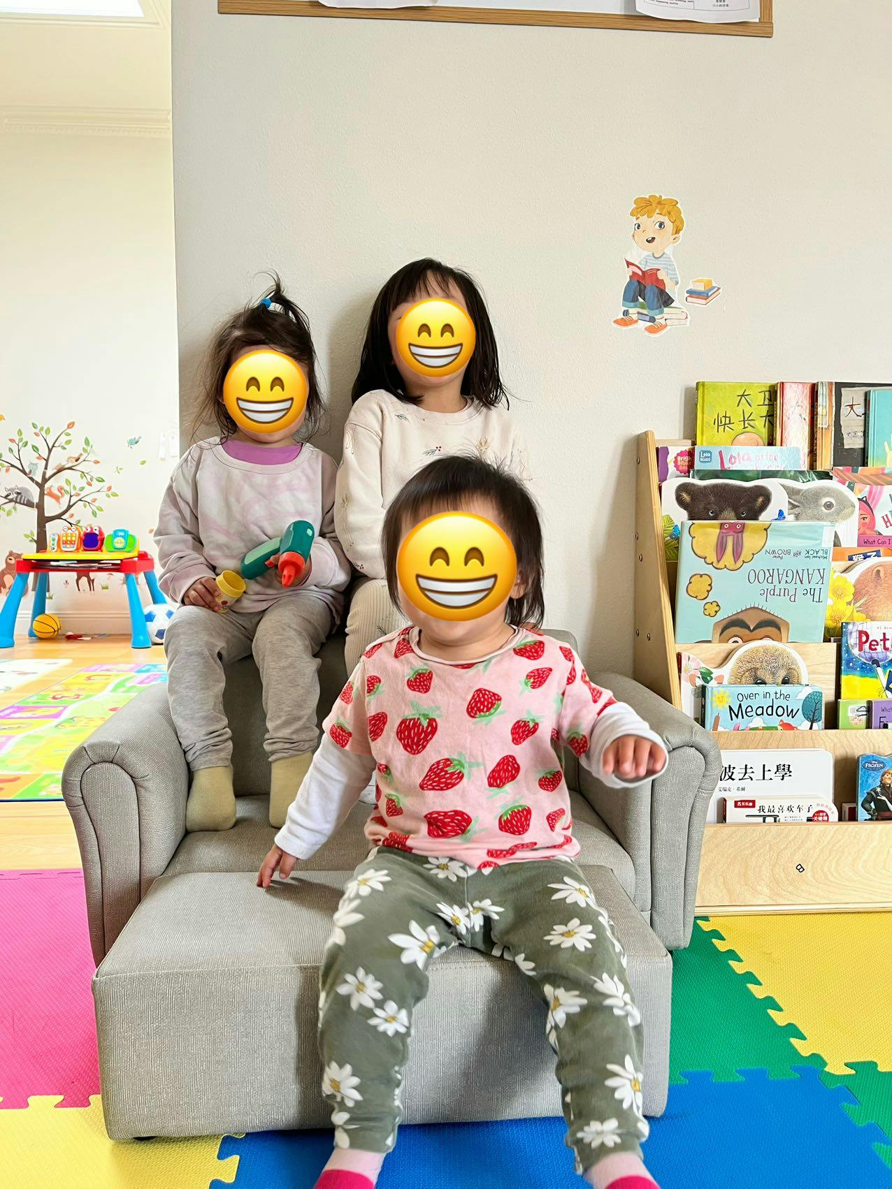 Three children sitting on a small sofa in a room