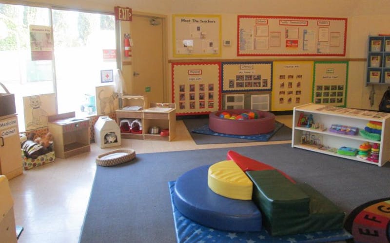 A classroom with play areas and educational posters on the walls
