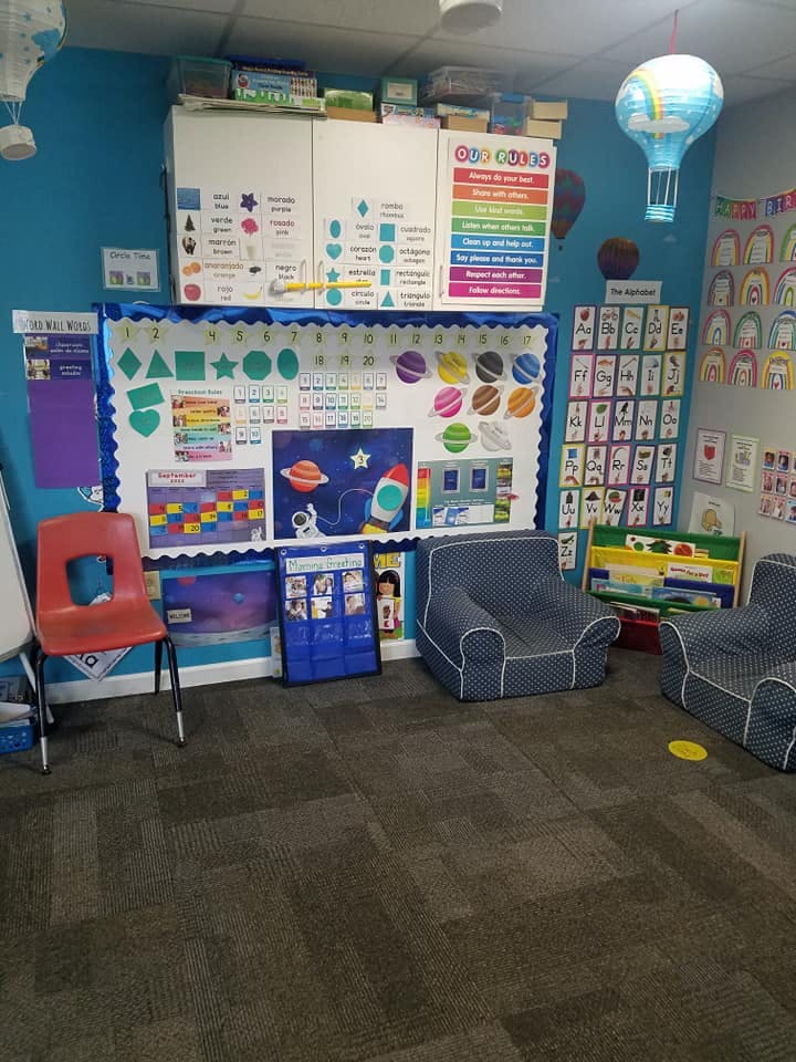 Classroom with educational posters on the walls, child-sized chairs, and bean bag chairs