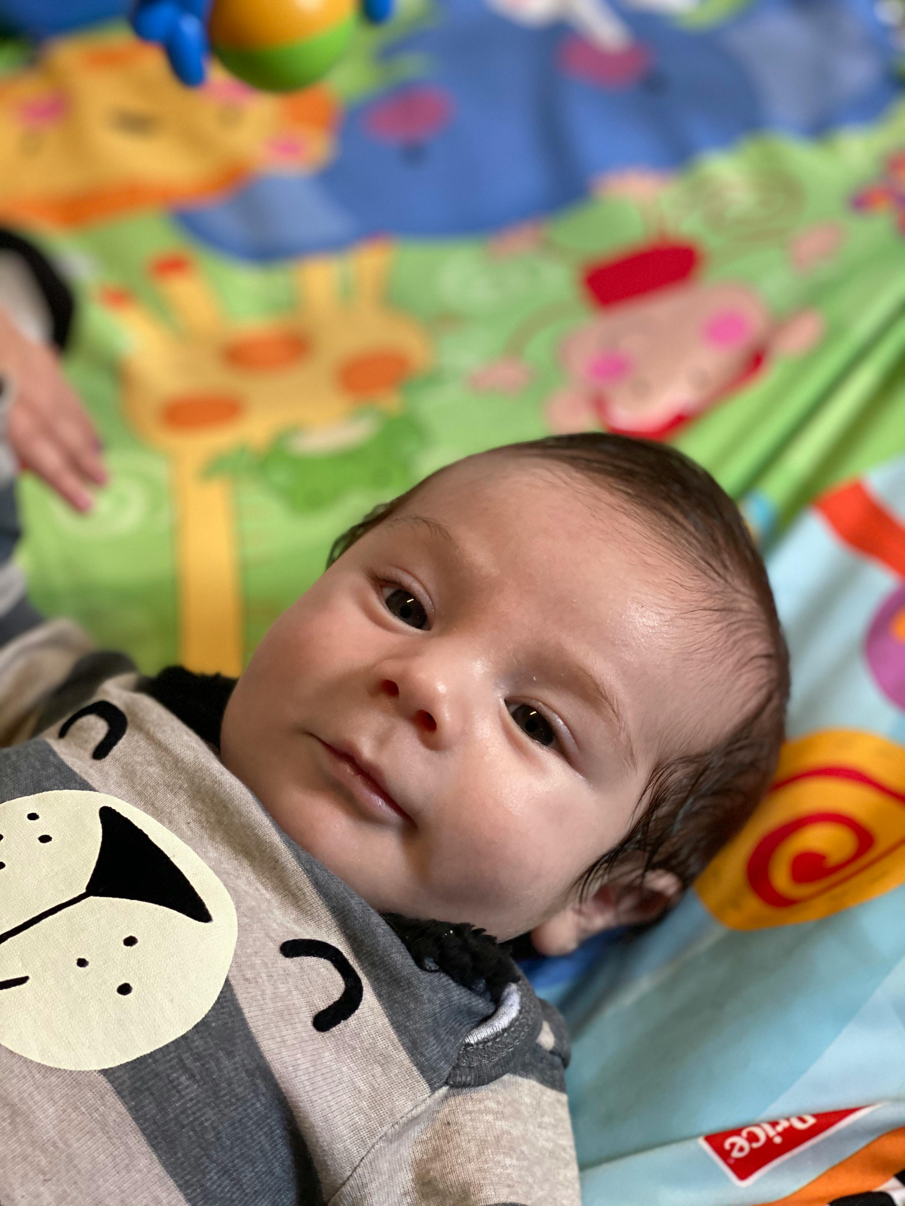 Child lying on a colorful play mat