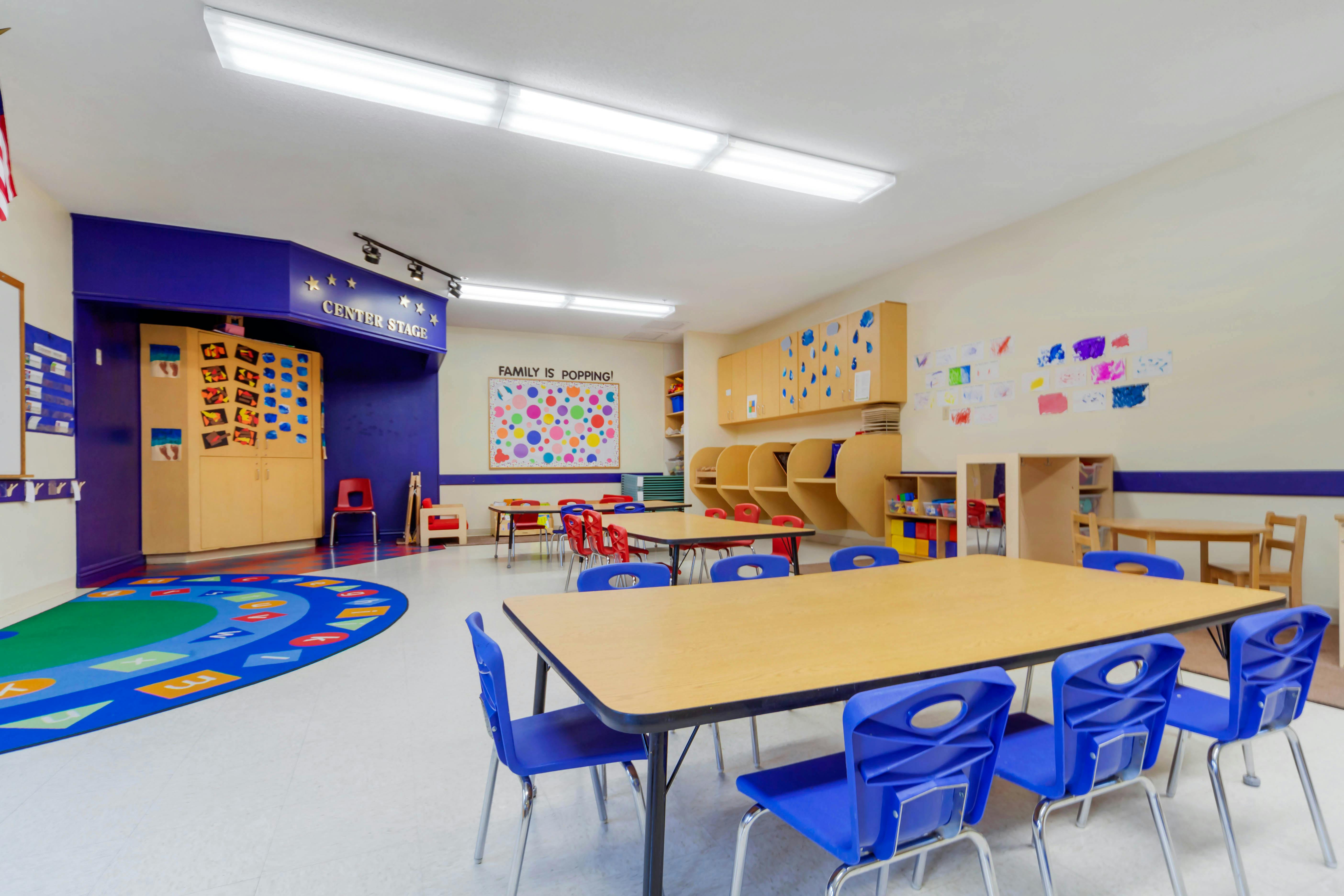 Empty colorful classroom with small tables and chairs
