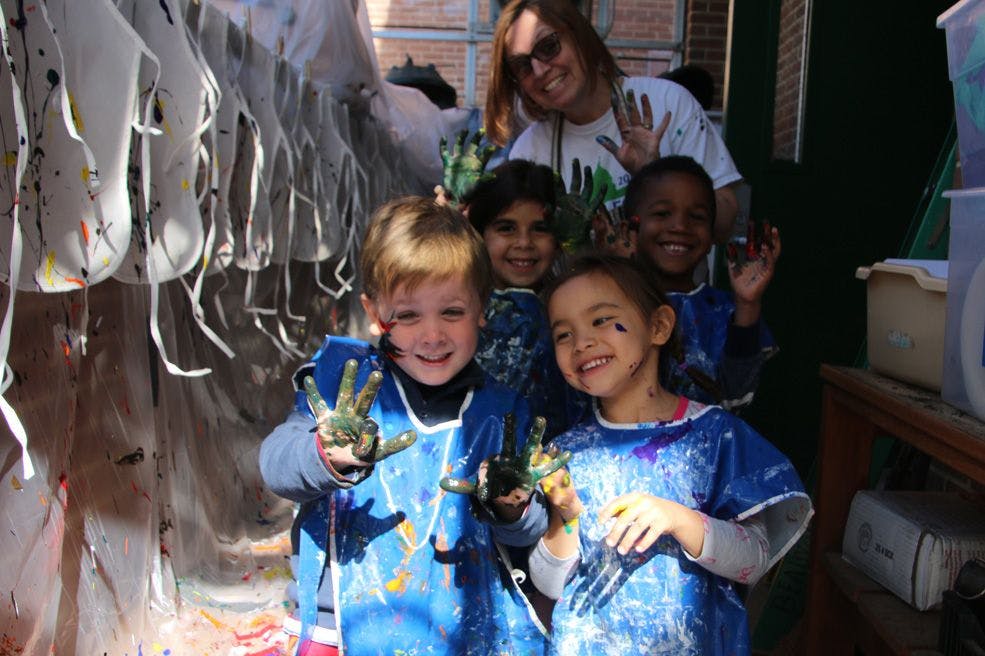 Children and an adult showing painted hands