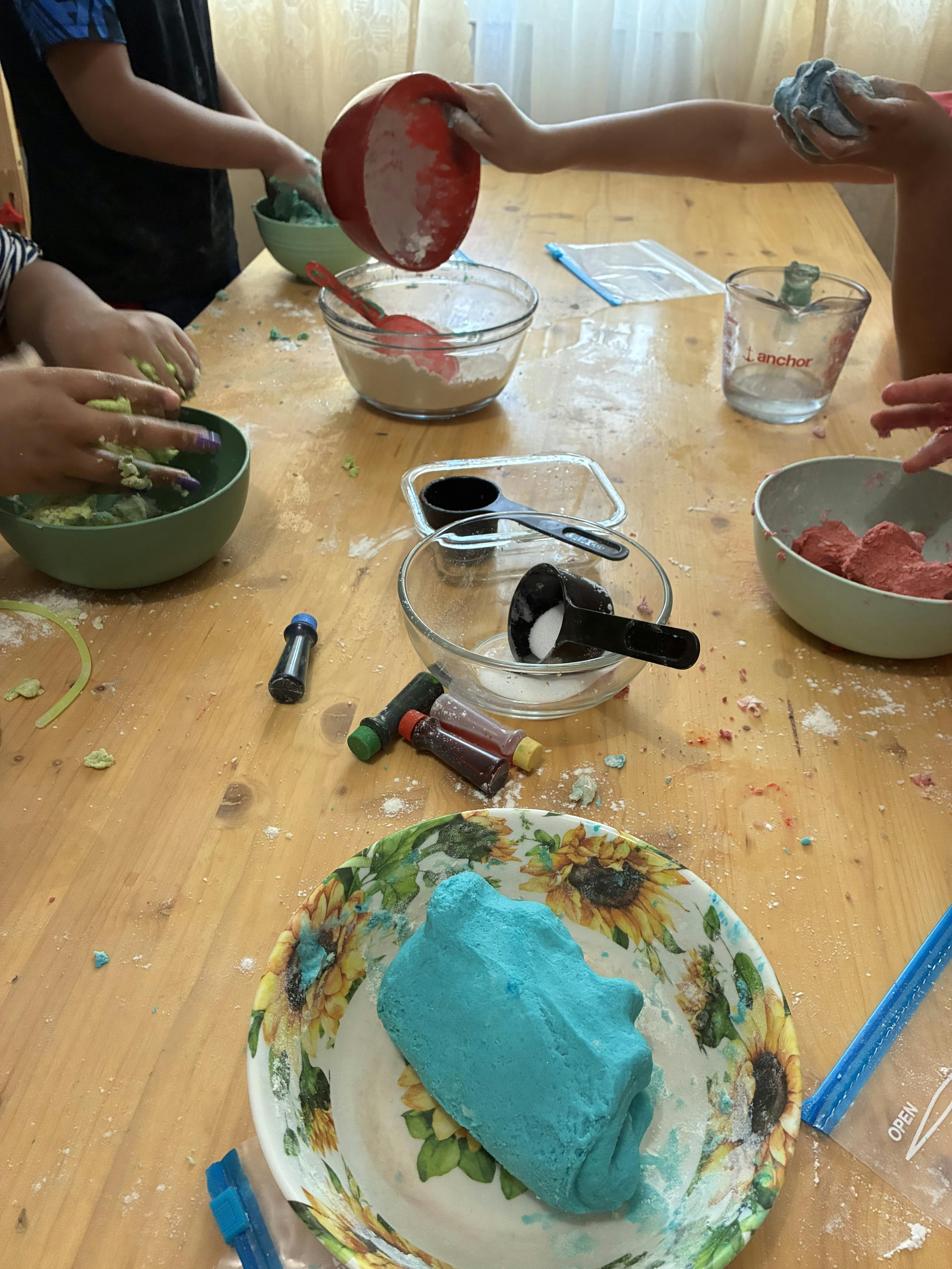 People making colorful dough at a table