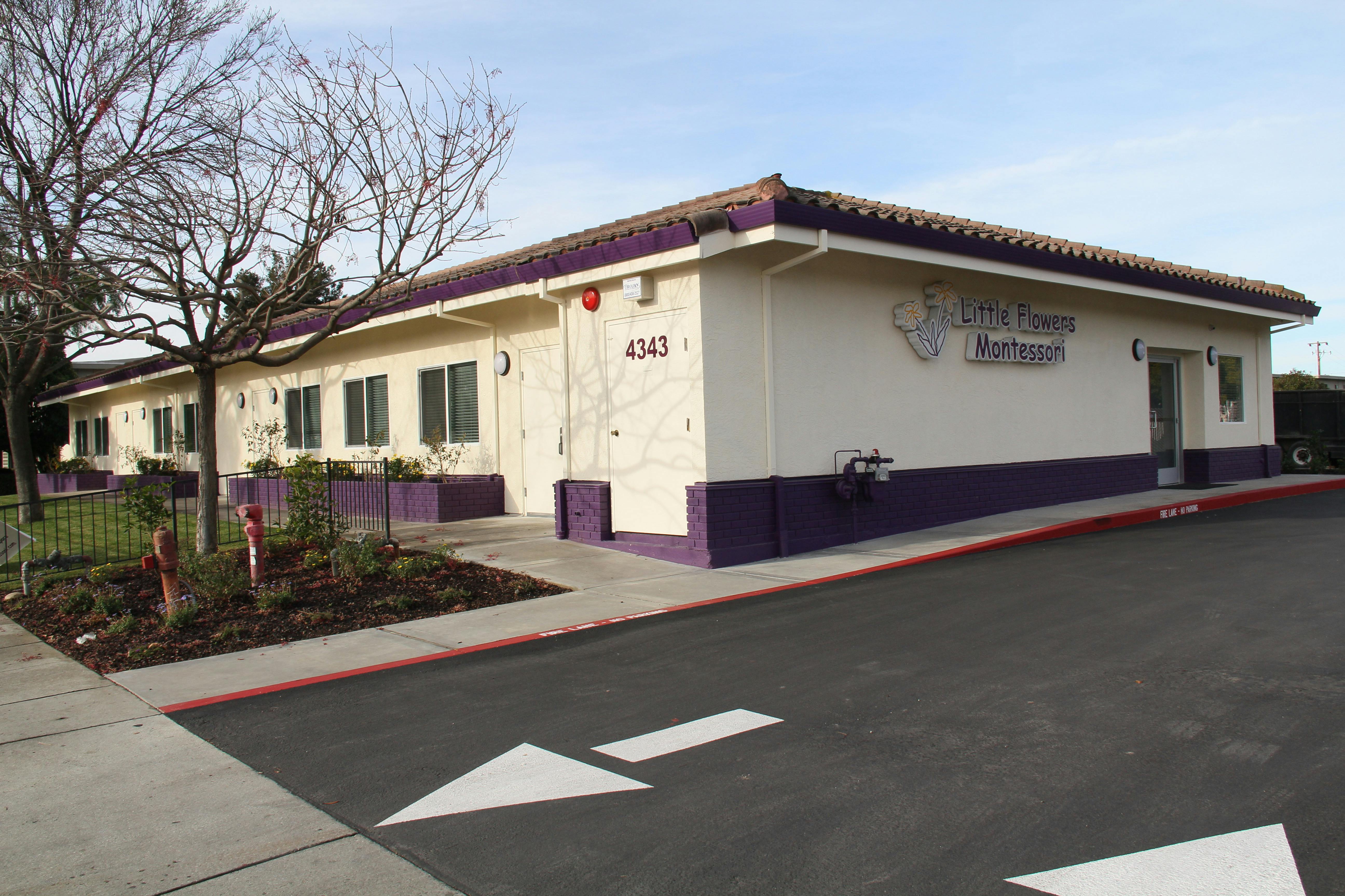 Building with purple trim and a parking lot with arrows