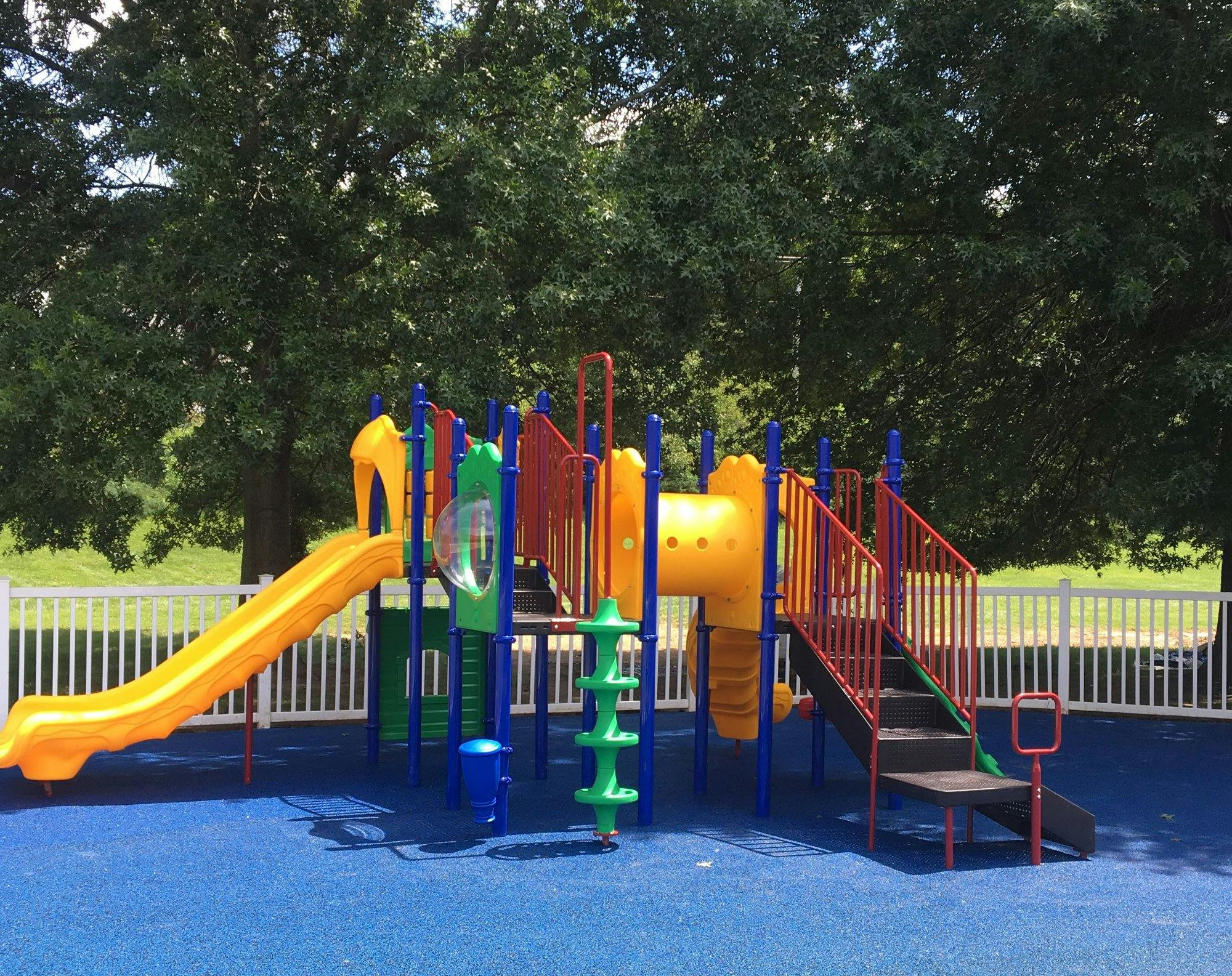 Colorful playground structure with slides and stairs on blue ground