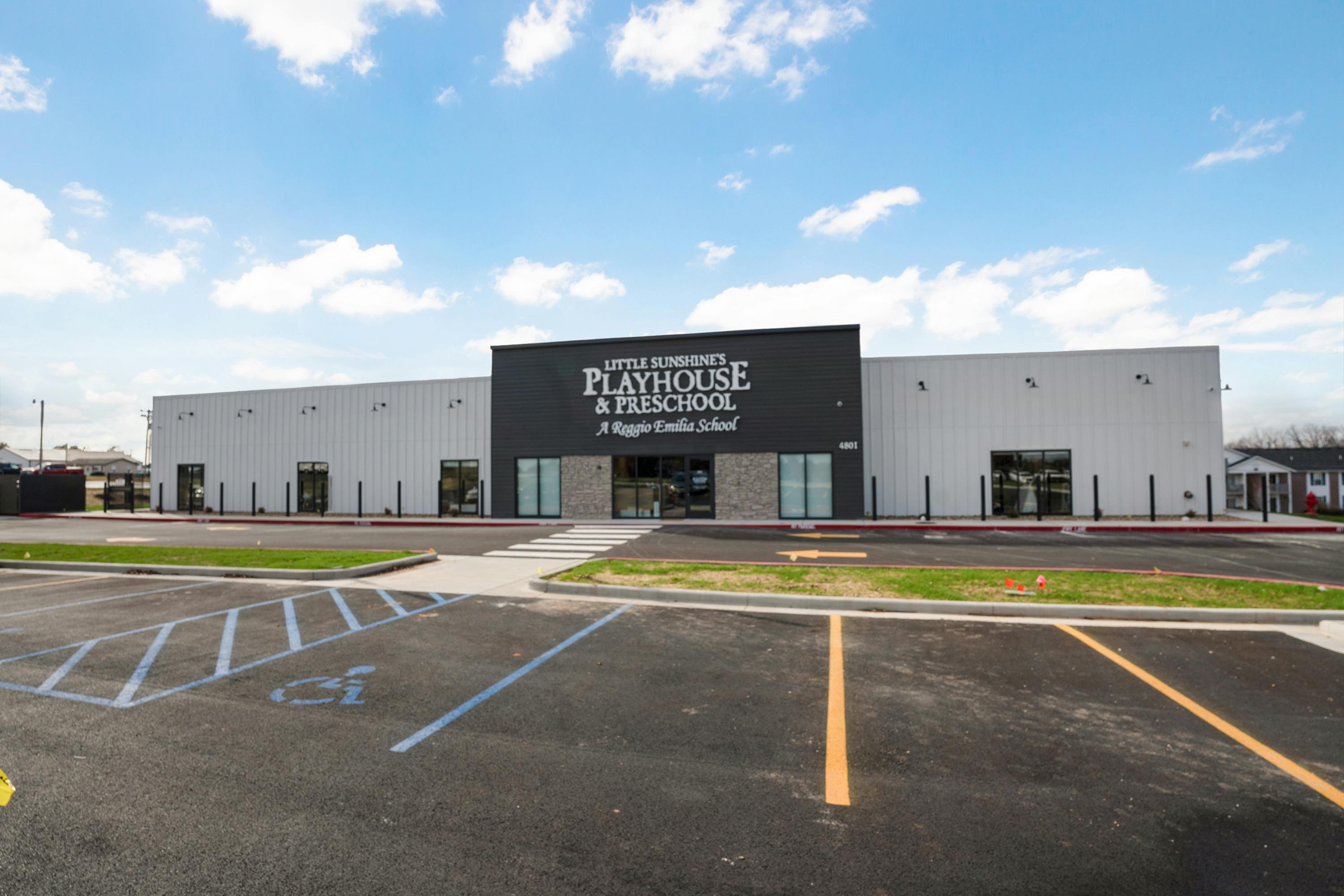 Building with "Playhouse & Preschool" sign and a parking lot