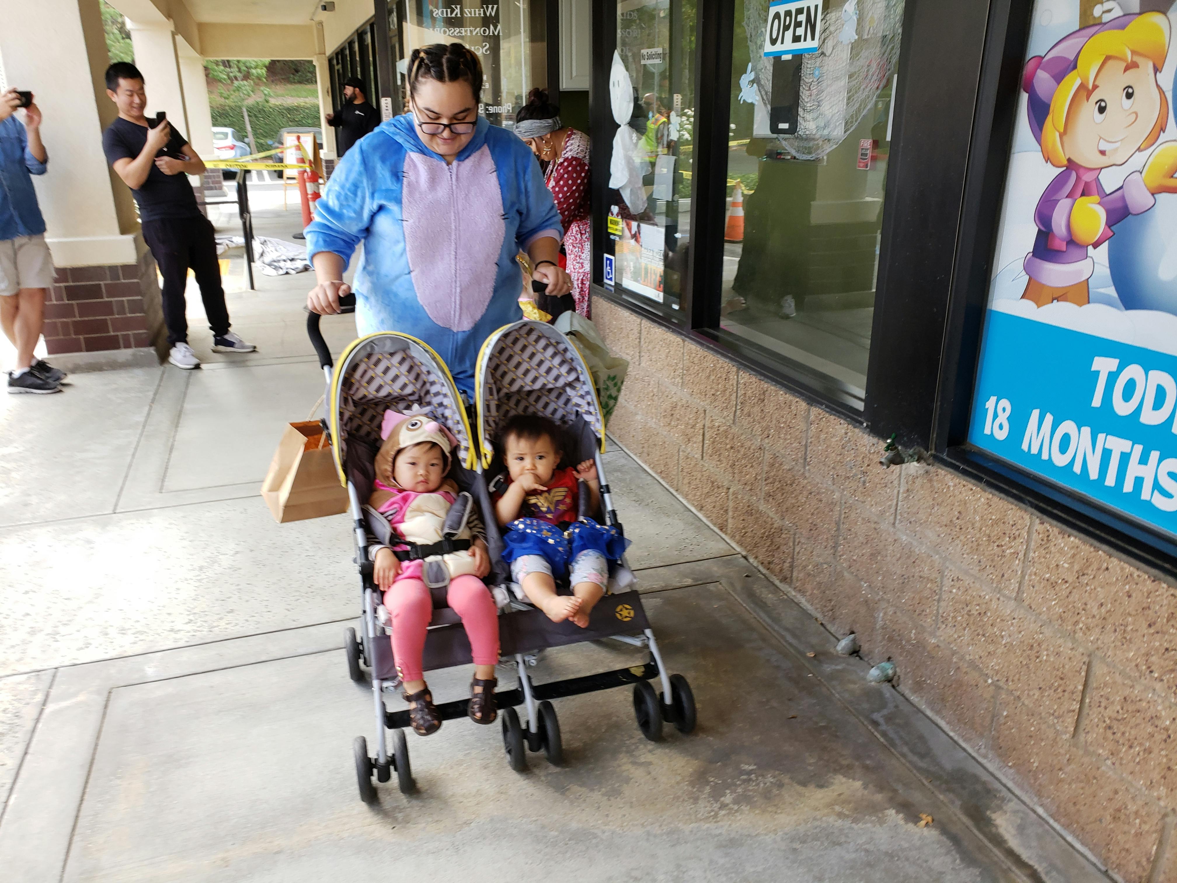 Person pushing a double stroller with two children