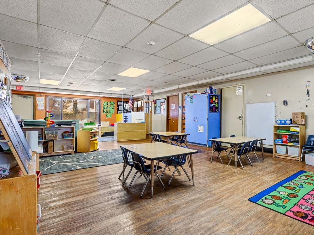 Empty classroom with small tables and chairs