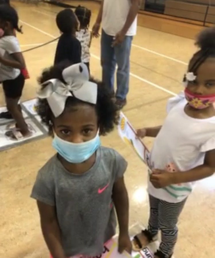 Child wearing a face mask and a large bow in their hair