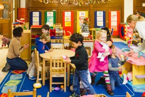Adults and children interacting in a classroom