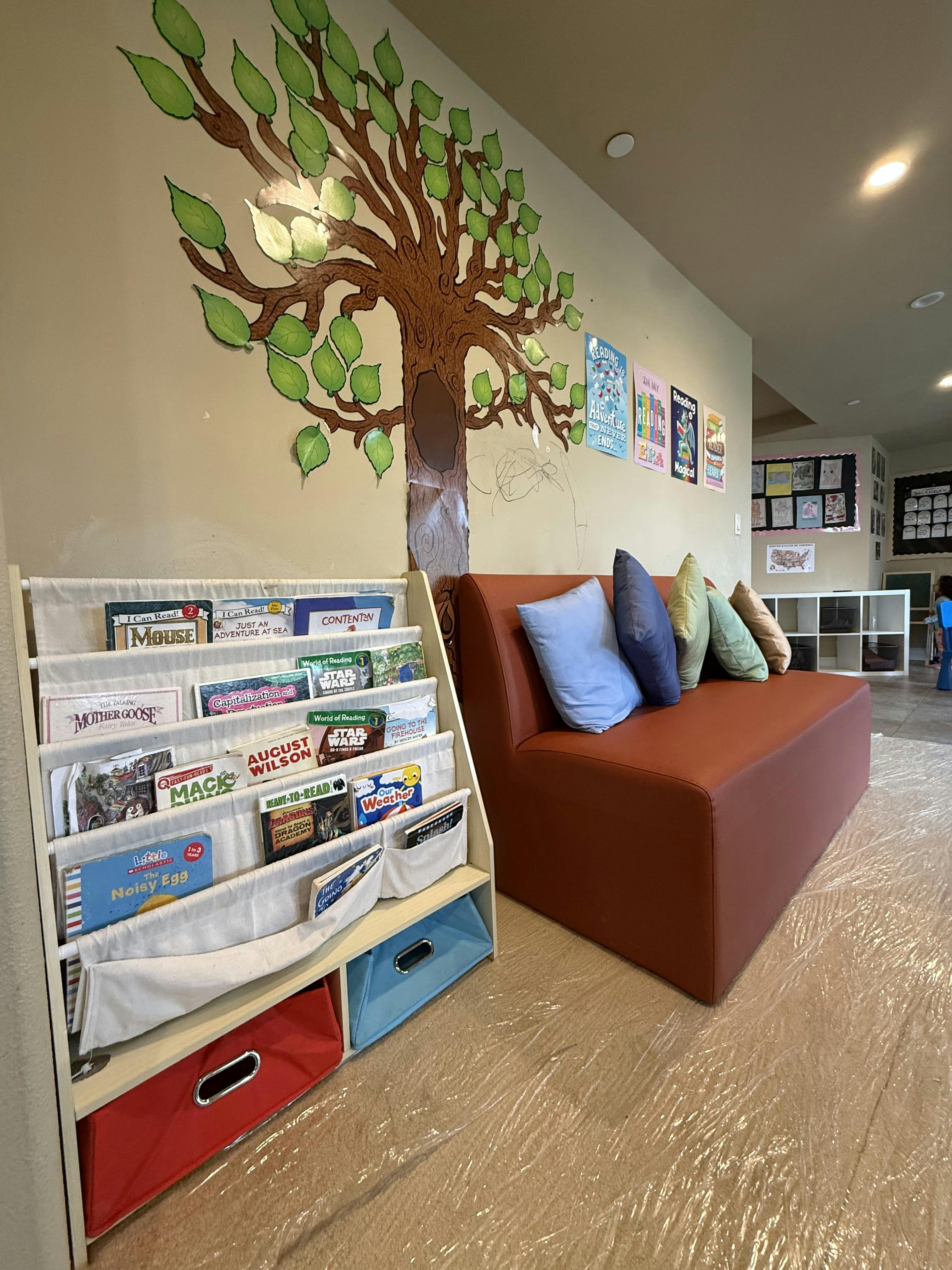 Bookshelf with children's books next to a seating area with pillows