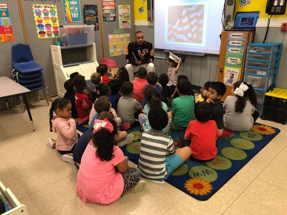 Adult reading to children sitting on a rug in a classroom