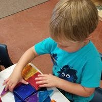Child playing with colorful magnetic tiles