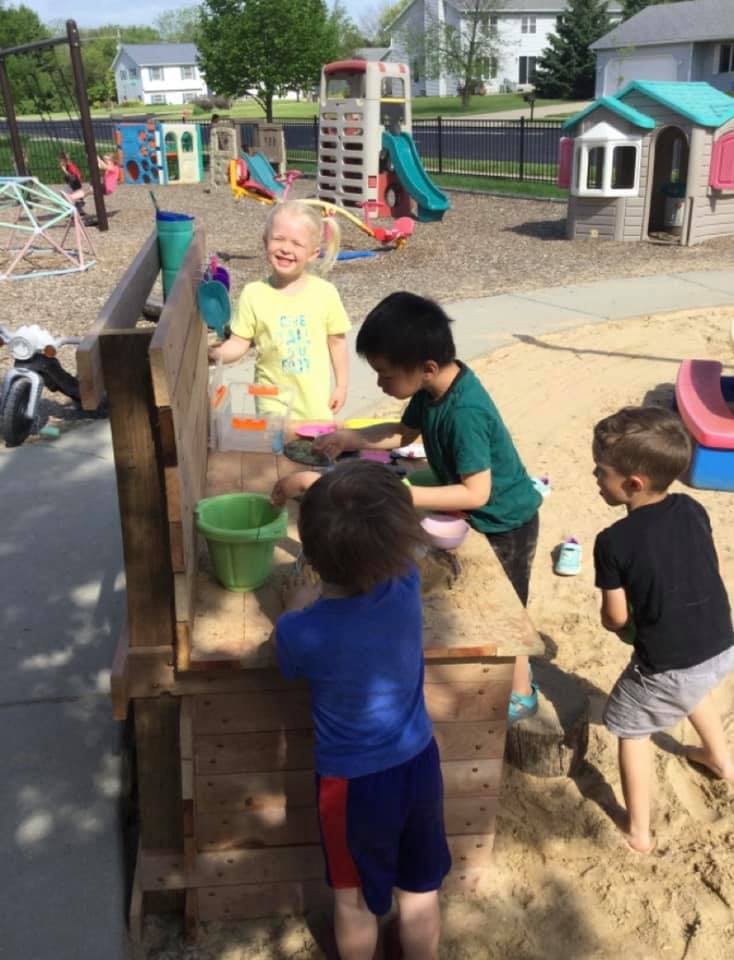 Children playing in a sandbox at a playground