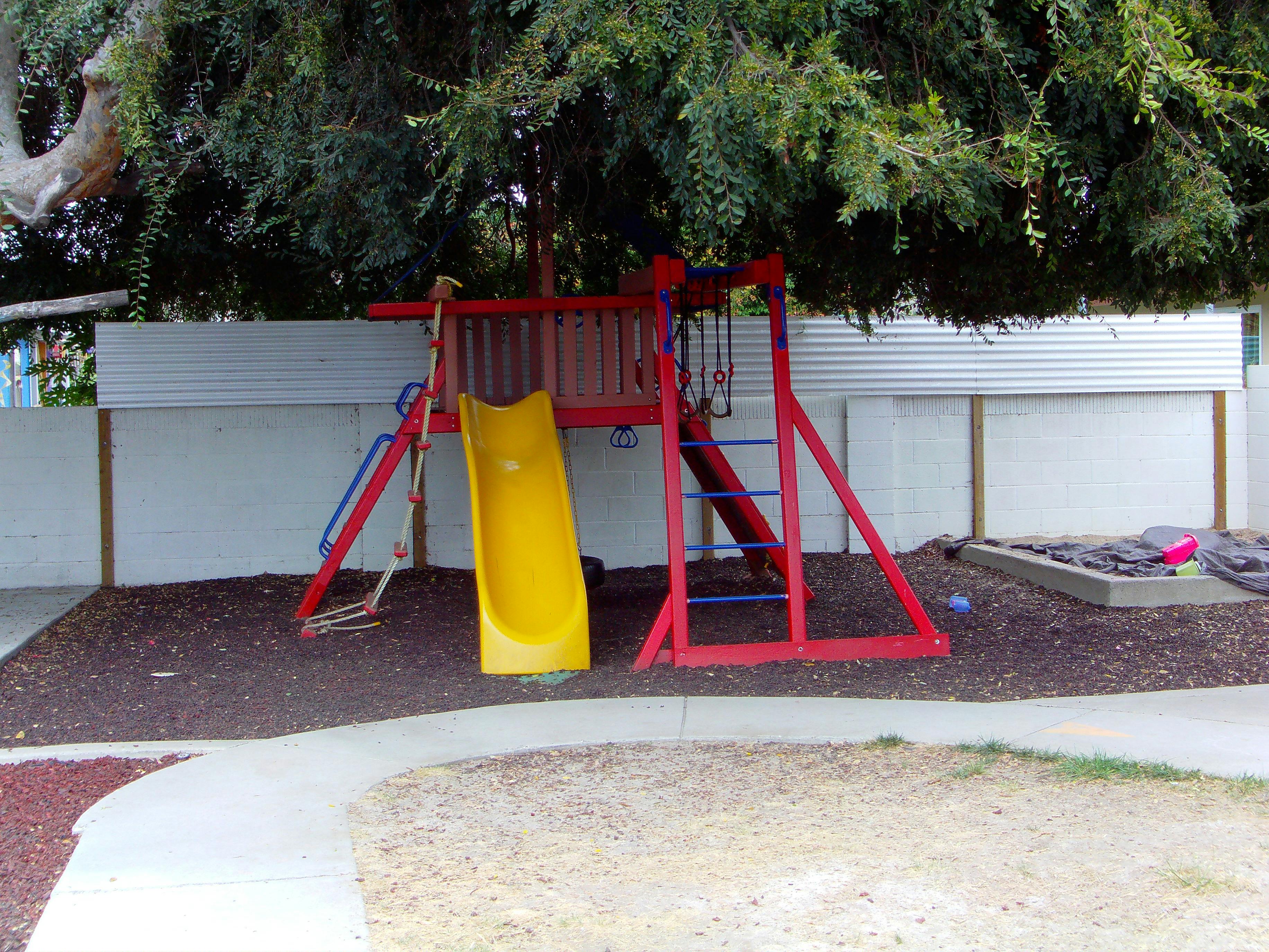 Red and yellow playground slide and swing set