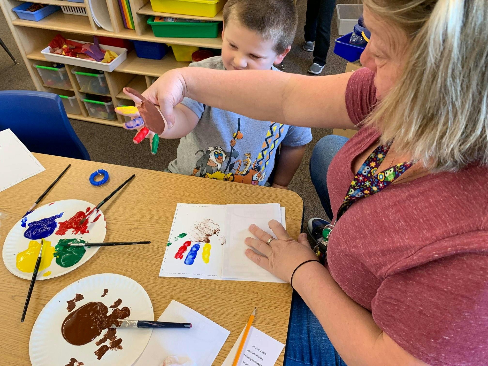 Adult and child finger painting at a table