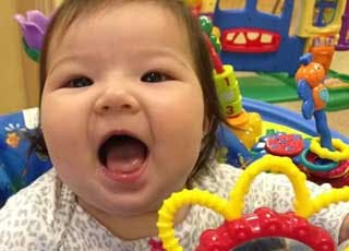 Child with mouth open near a toy