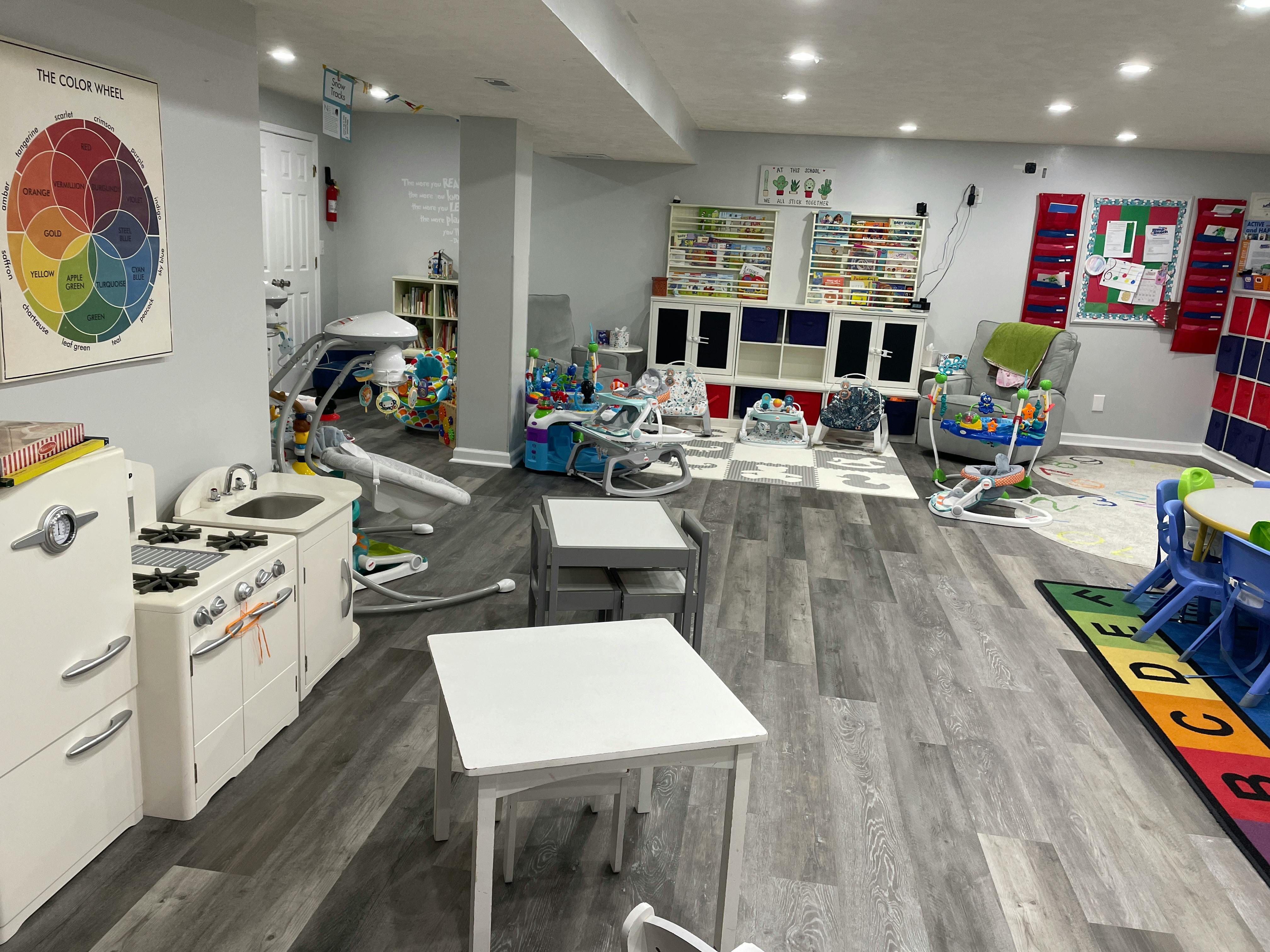 Playroom with small tables, toy kitchen, and various child activity centers