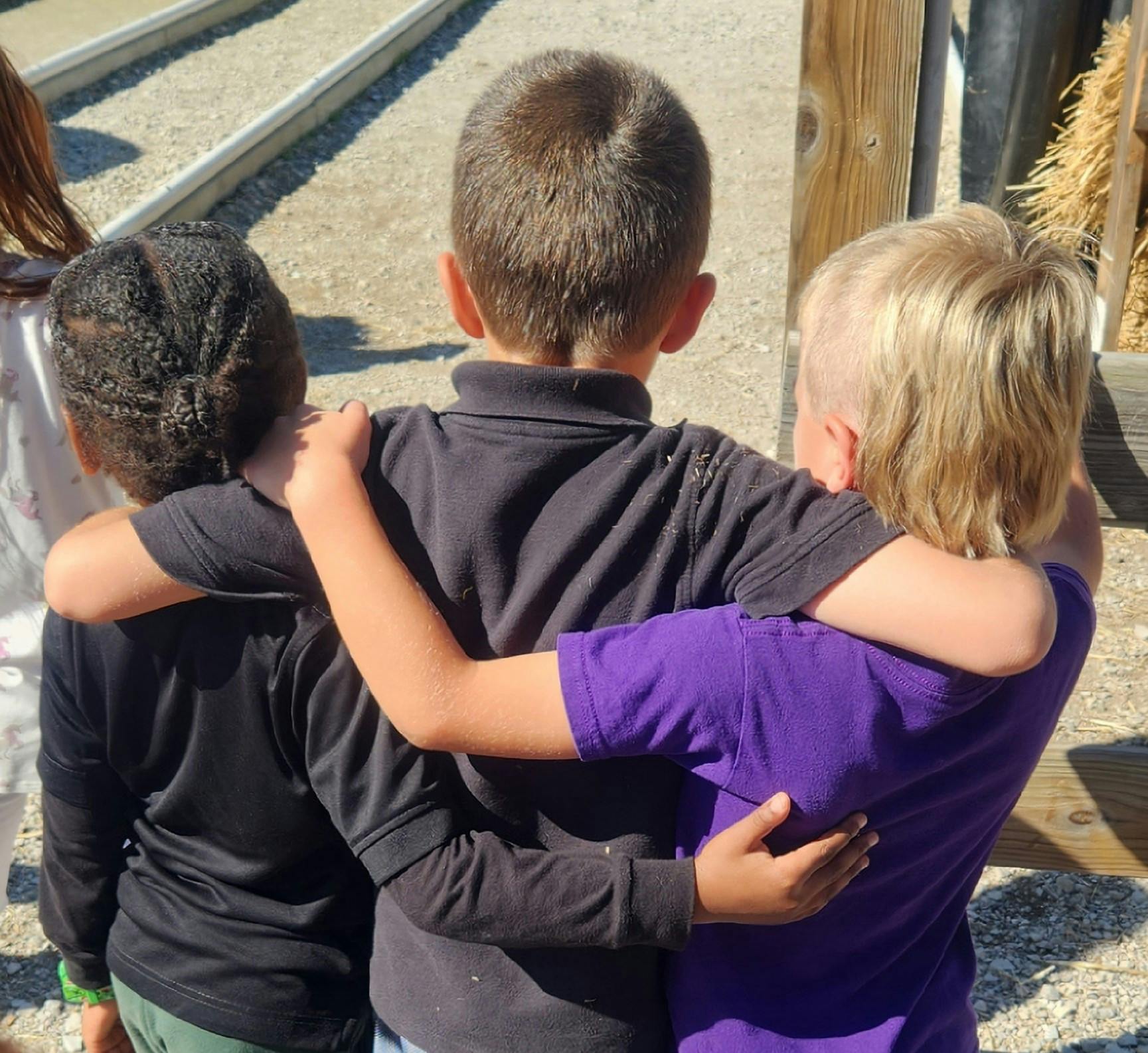 Three children with arms around each other