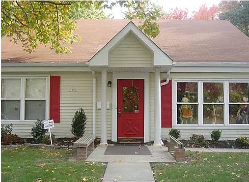 Front of a house with a red door and red shutters
