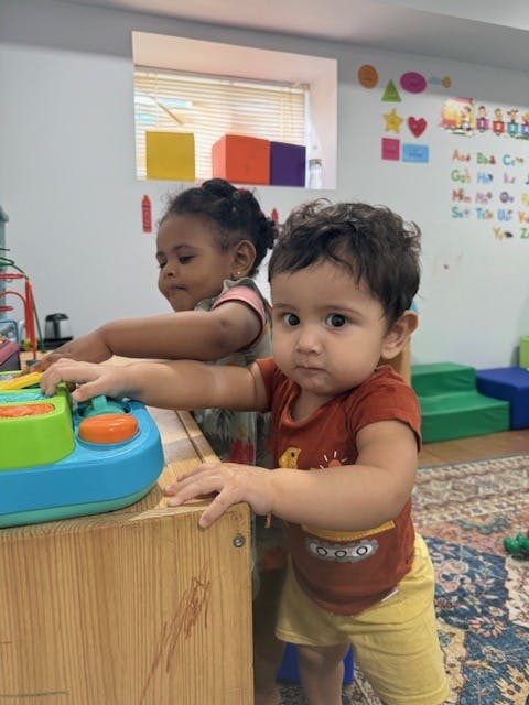 Two children playing with a toy in a classroom