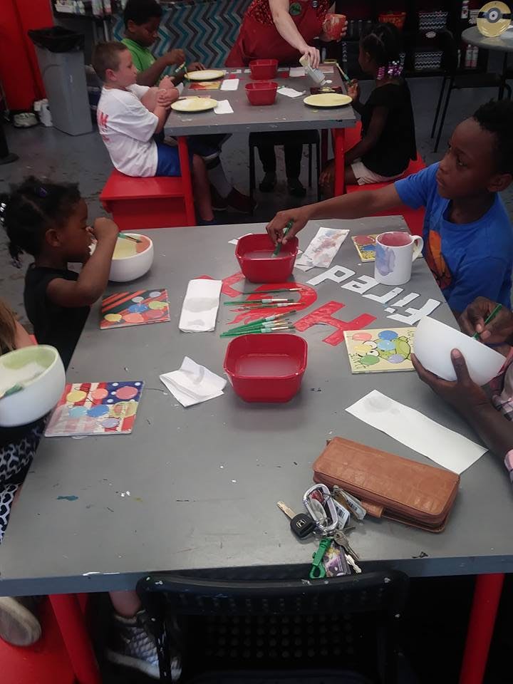 Children at a table with art supplies and bowls