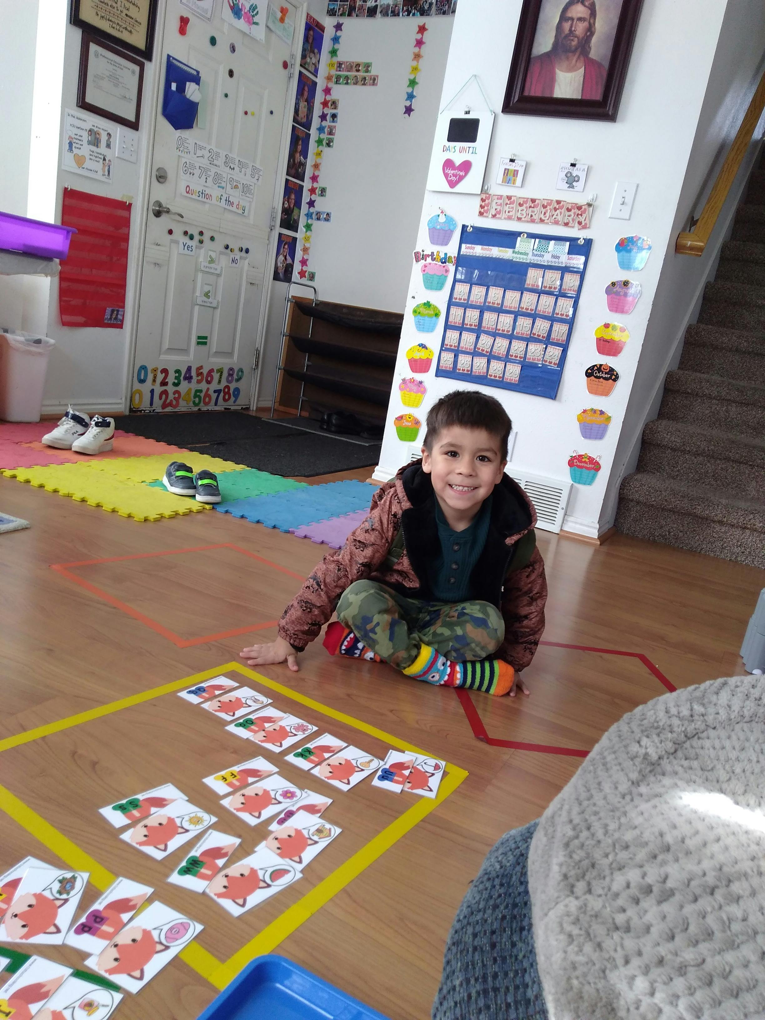 Child sitting on floor with cards in a room with cards on the floor