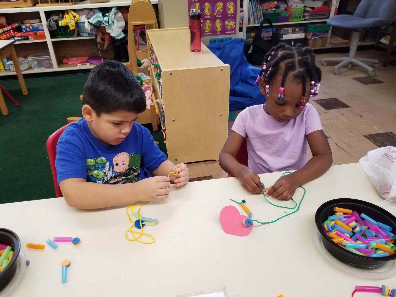 Two children at a table doing crafts in-class activities