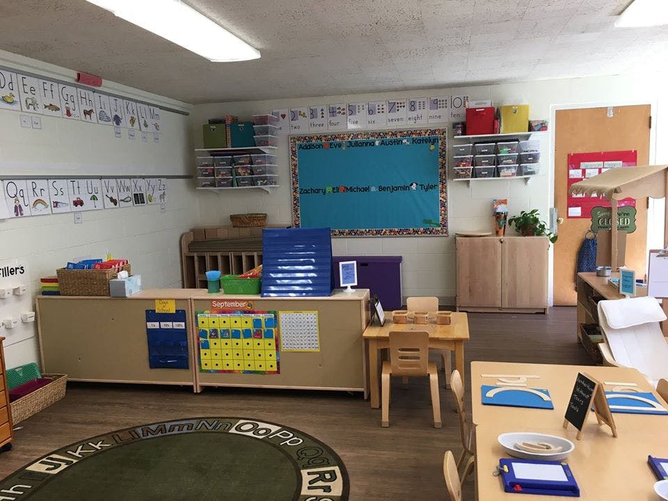 Classroom with small tables and chairs, bulletin boards, and learning materials