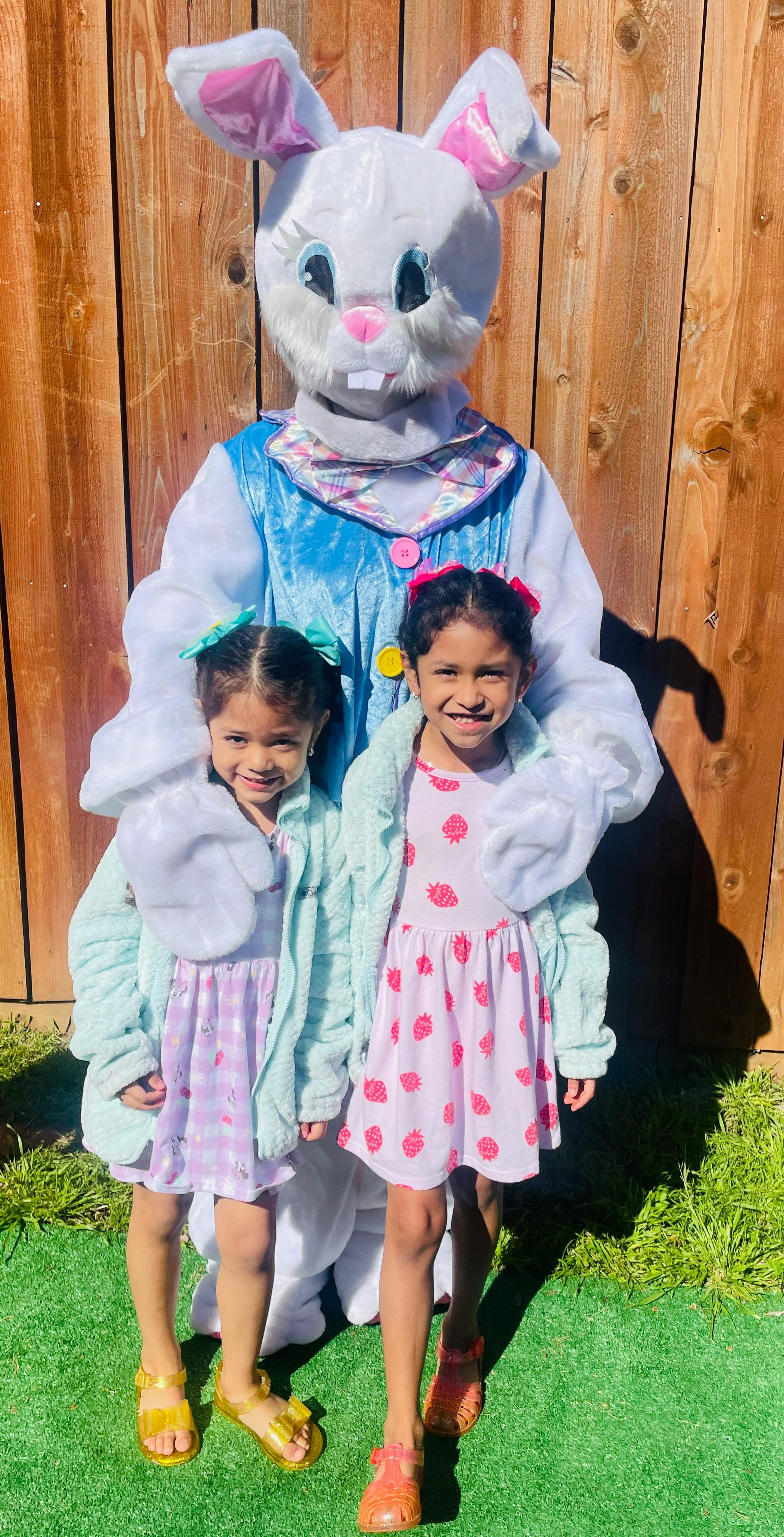 Person in a bunny costume with two children