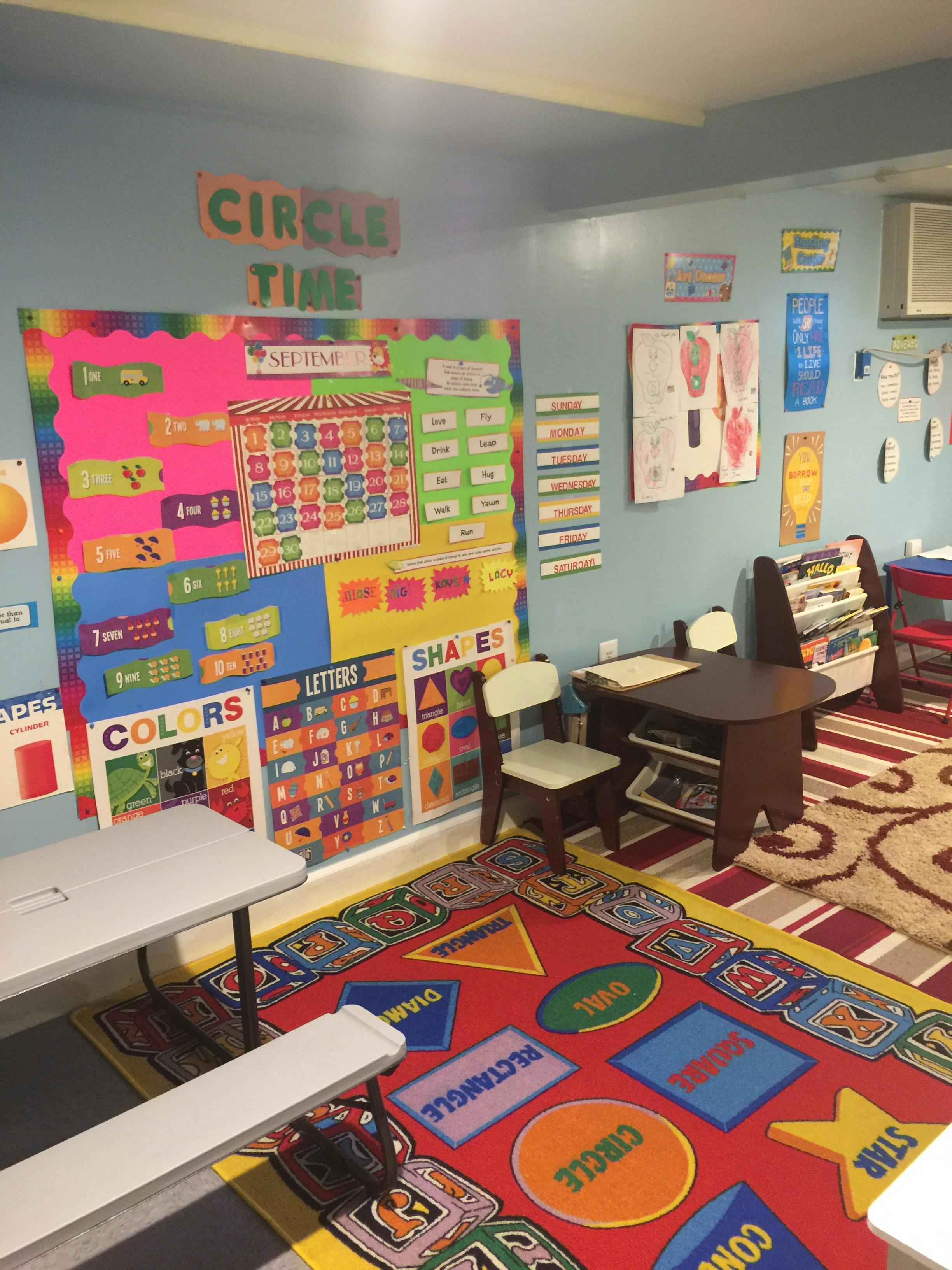 Classroom with colorful educational posters and a rug with shapes