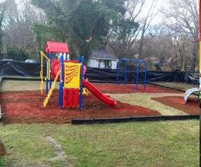 Playground with red and yellow play structure and slide
