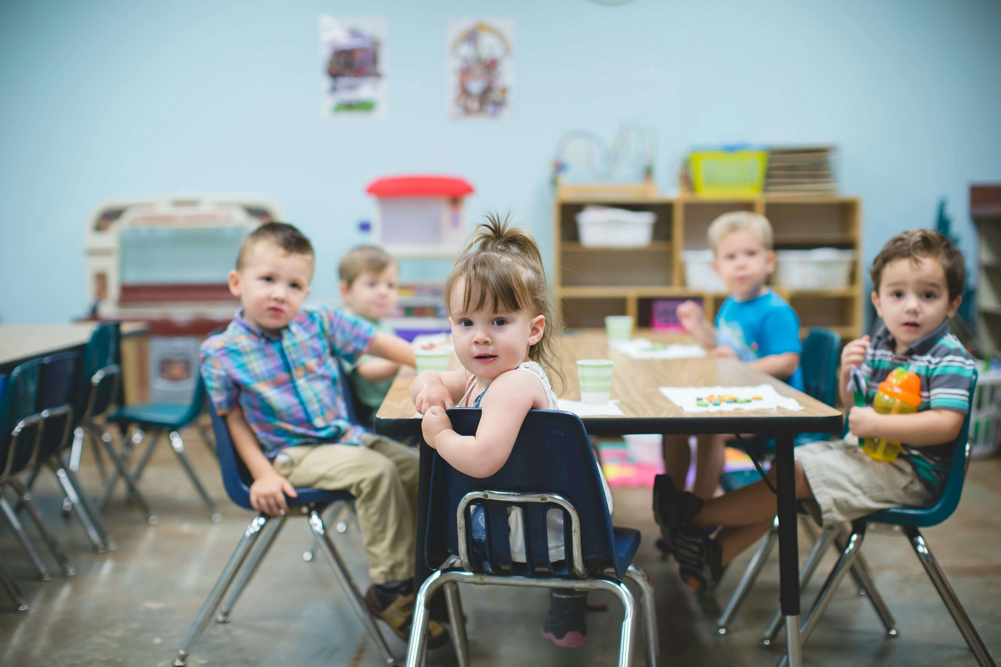 Children sitting at tables in a classroom